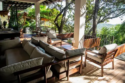 a patio with couches and chairs on a deck at Tierra Magnifica Boutique Hotel in Nosara