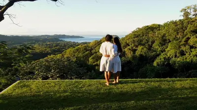 a woman in a white dress standing on top of a hill at Tierra Magnifica Boutique Hotel in Nosara
