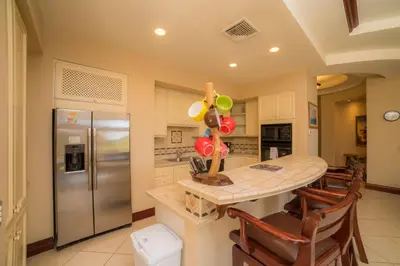 a kitchen with a table and a stainless steel refrigerator at Bella Vista 2C 3 bdrs pool view in Los Suenos in Herradura