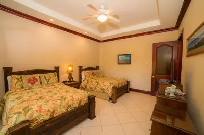 a bedroom with two beds and a ceiling fan at Bella Vista 2C 3 bdrs pool view in Los Suenos in Herradura