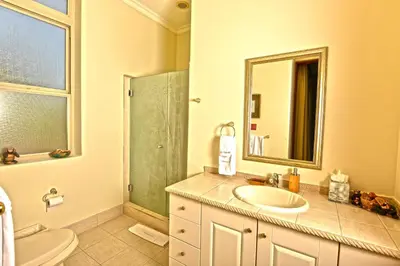 a bathroom with a sink and a toilet and a mirror at Bella Vista 4B 3 bdrs ocean view in Los Suenos in Herradura