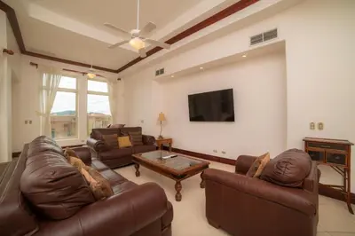 a living room with leather furniture and a flat screen tv at Bella Vista 2B 3 bdrs pool view in Los Suenos in Herradura