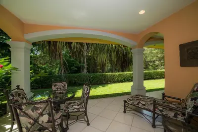 a patio with a table and chairs and a garden at Colina 9E 2 bdr Garden View in Los Suenos in Herradura