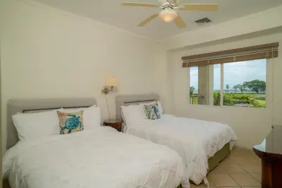 a bedroom with two beds and a ceiling fan at Del Mar 3i 3 bdr Ocean View in Los Suenos in Herradura