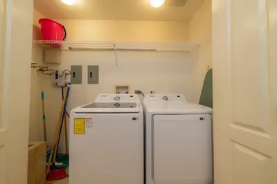 a laundry room with two machines and a sink at Del Mar 3i 3 bdr Ocean View in Los Suenos in Herradura