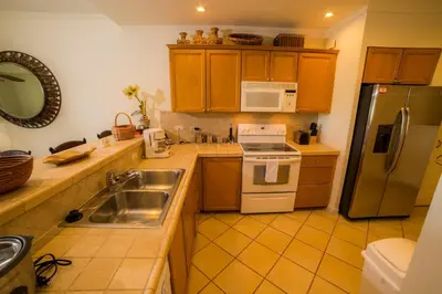 a kitchen with a sink and a refrigerator at Del Mar 3N 3 bdr Garden View in Los Suenos in Herradura