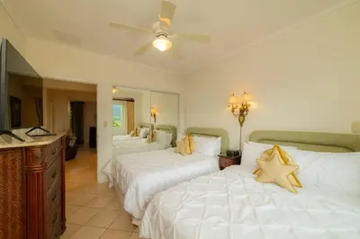 a bedroom with two beds and a ceiling fan at Del Mar 4G 3 bdr Garden View in Los Suenos in Herradura