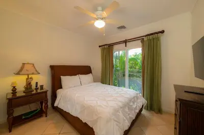 a bedroom with a bed with a ceiling fan and a window at Del Mar 4G 3 bdr Garden View in Los Suenos in Herradura