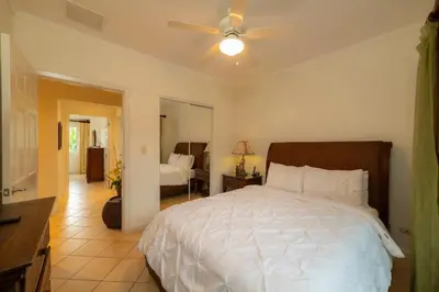 a bedroom with a white bed with a ceiling fan at Del Mar 4G 3 bdr Garden View in Los Suenos in Herradura