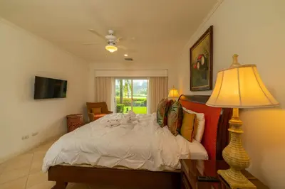 a bedroom with a bed with a lamp and a window at Del Mar 4O 2 bdr Garden View in Los Suenos in Herradura