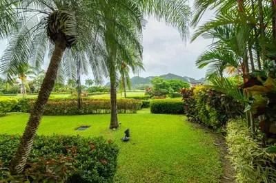 a bird standing in a park with palm trees at Del Mar 4O 2 bdr Garden View in Los Suenos in Herradura