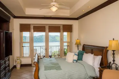 a bedroom with a bed with a view of the water at Marbella 2A 3 bdr Ocean View in Los Suenos in Herradura
