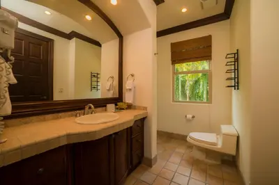 a bathroom with a sink and a toilet and a mirror at Marbella 2A 3 bdr Ocean View in Los Suenos in Herradura