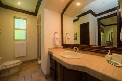 a bathroom with a sink and a toilet and a mirror at Marbella 2A 3 bdr Ocean View in Los Suenos in Herradura