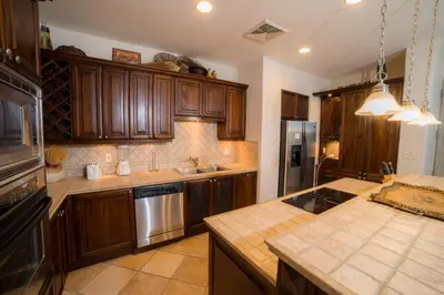 a kitchen with wooden cabinets and stainless steel appliances at Marbella 3D 3 bdr Ocean View in Los Suenos in Herradura