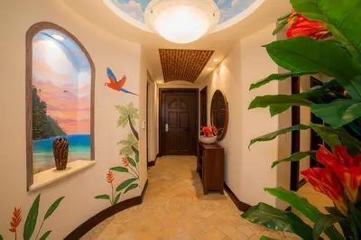 a hallway with a door with a painting on the wall at Marbella 3D 3 bdr Ocean View in Los Suenos in Herradura