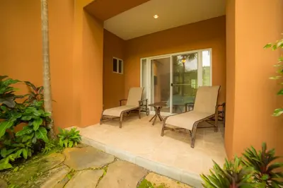 a patio with chairs and a table in a house at Veranda 8F 2 bdr Garden View in Los Suenos in Herradura