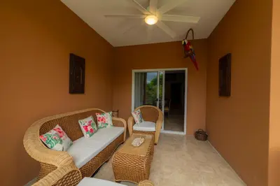a living room with wicker chairs and a ceiling fan at Veranda 4B 3 bdr Golf Course View in Los Suenos in Herradura