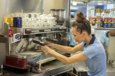 a woman in a kitchen using a coffee machine at Veranda 4B 3 bdr Golf Course View in Los Suenos in Herradura
