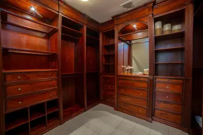 a walk in closet with wooden cabinets and a mirror at Bella Vista 3F 3 bdr beach club view in Los Suenos in Herradura
