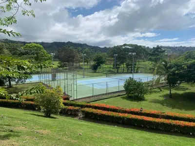 a tennis court in a park with flowers at Bella Vista 3F 3 bdr beach club view in Los Suenos in Herradura