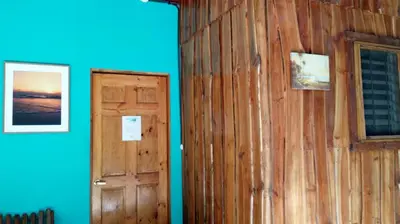 a room with a door and a blue wall at J Bay : Burnt Toast Surfcamp in Nosara