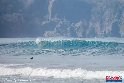 a person riding a wave on a surfboard in the ocean at J Bay : Burnt Toast Surfcamp in Nosara