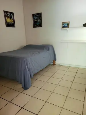 a bedroom with a bed and a tiled floor at J Bay : Burnt Toast Surfcamp in Nosara
