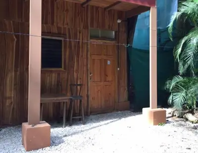 a wooden building with a bench and a wooden door at J Bay : Burnt Toast Surfcamp in Nosara