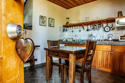 a kitchen with a wooden table and chairs at Arco Iris Lodge in Monteverde Costa Rica