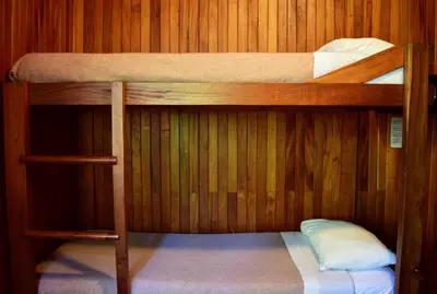 two bunk beds in a room with wooden walls at Arco Iris Lodge in Monteverde Costa Rica
