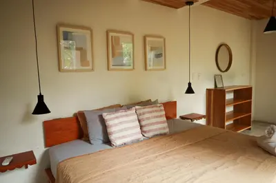 a bedroom with a bed and three pictures on the wall at Zeneidas Surf Garden in Santa Teresa Beach