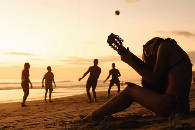 a group of people playing guitar on the beach at Zeneidas Surf Garden in Santa Teresa Beach