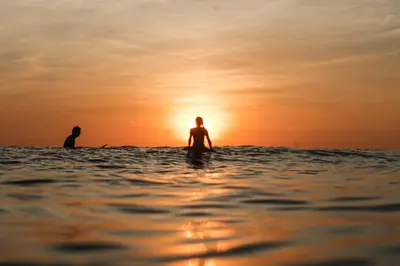 two people in the water at the sunset at Zeneidas Surf Garden in Santa Teresa Beach