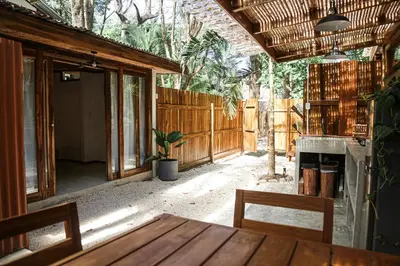 an outdoor patio with a table and a fireplace at Zeneidas Surf Garden in Santa Teresa Beach