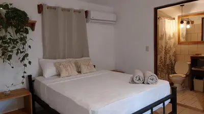 a bedroom with a white bed with towels on it at Zeneidas Surf Garden in Santa Teresa Beach