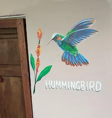 a hummingbird painted on the side of a wall at Peace of Paradise Breakfast Included Free Manuel Antonio Park Tour in Manuel Antonio