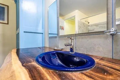 a blue sink in a bathroom with a mirror at Peace of Paradise Breakfast Included Free Manuel Antonio Park Tour in Manuel Antonio