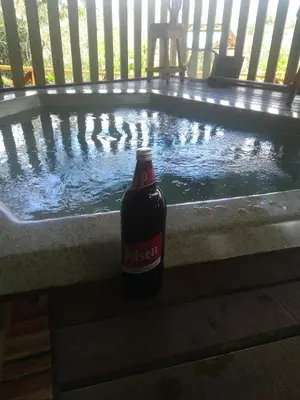 a bottle of beer sitting in front of a swimming pool at Corredores del Pacuare in La Suiza