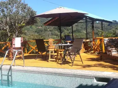a patio with a table and an umbrella next to a pool at Corredores del Pacuare in La Suiza