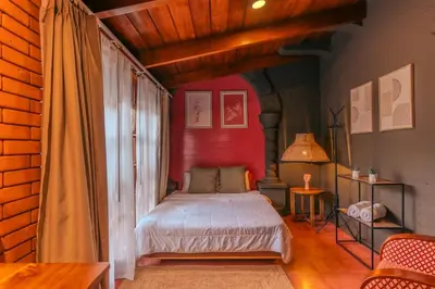 a bedroom with a bed with a red wall at awā San José in San José