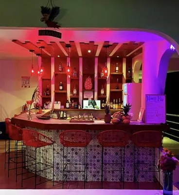 a kitchen with a bar with pink lighting at The Scarlet Villas in Ojochal