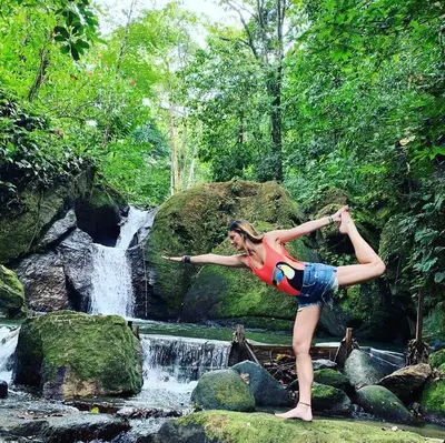 a woman standing on rocks in front of a waterfall at The Scarlet Villas in Ojochal