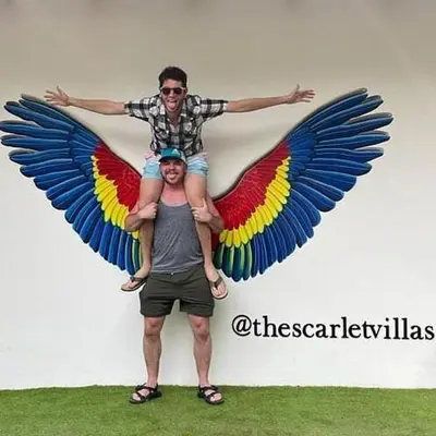 a man holding a child with wings on his shoulders at The Scarlet Villas in Ojochal