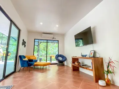 a living room with a blue chair and a tv at The Scarlet Villas in Ojochal
