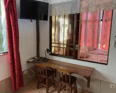 a room with a wooden table and a television on a wall at Pacific Jungle Condominium in Playa Hermosa