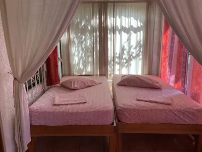 two twin beds in a room with a window at Pacific Jungle Condominium in Playa Hermosa