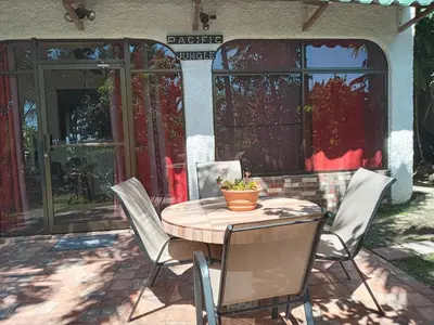 a wooden table and chairs on a patio at Pacific Jungle Condominium in Playa Hermosa