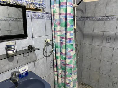 a bathroom with a shower curtain and a sink at Pacific Jungle Condominium in Playa Hermosa