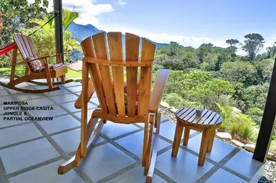 a pair of chairs on a porch with a view at Nature's Edge Boutique Hotel in Uvita